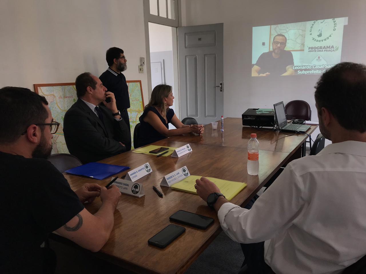 Imagem mostra foto da reunião durante exibição de vídeo explicativo sobre o projeto